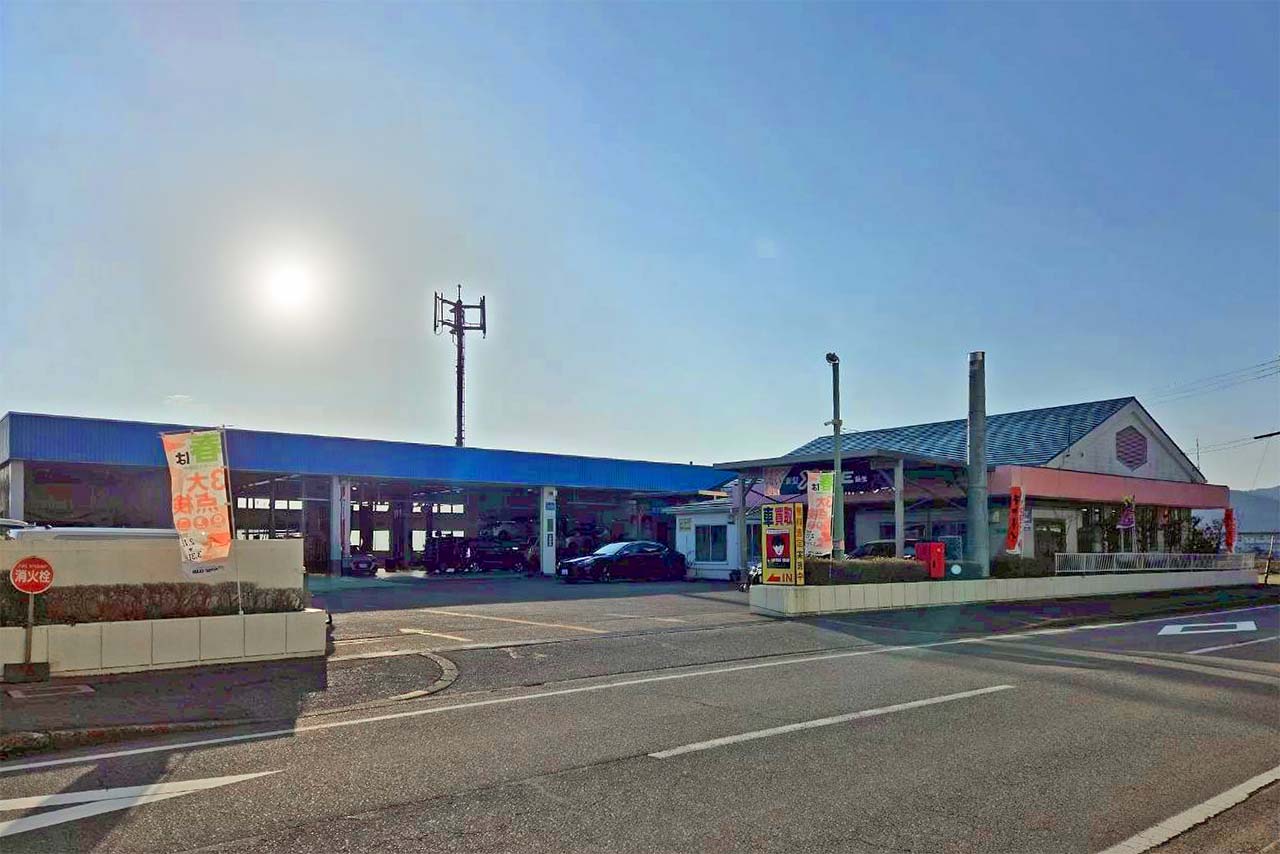 広い敷地を持つ青い工場建屋と事務所の遠景