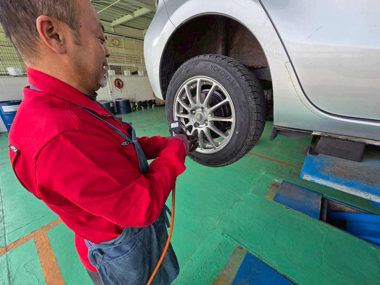 工具を使って車のタイヤを整備しているスタッフの手元
