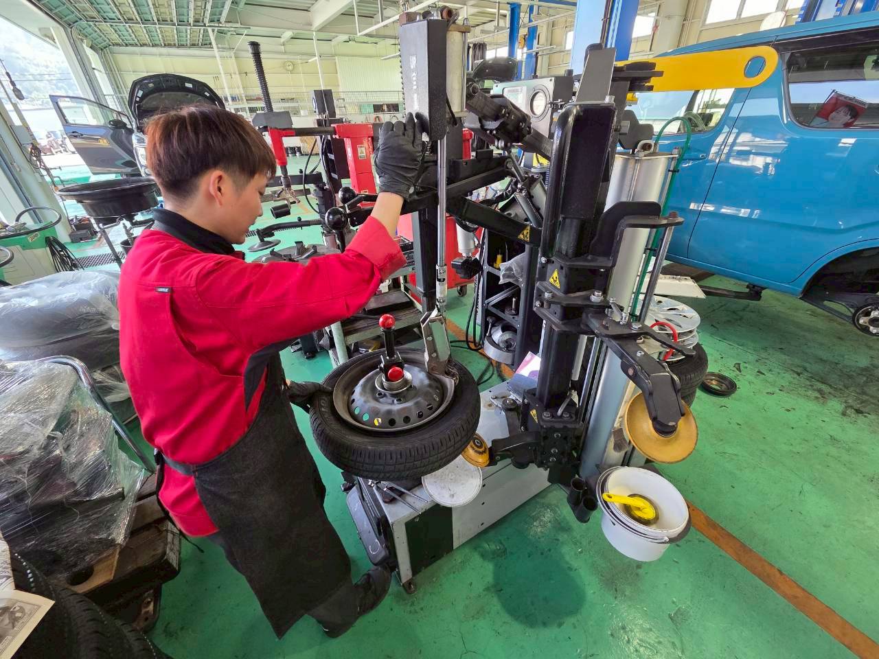 スタッフが専用の機械を使ってタイヤの交換作業を行っている様子